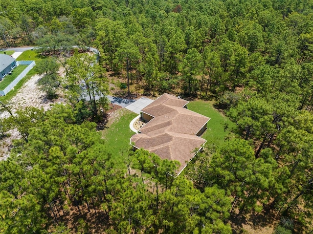 aerial view of property and surrounding area with a heavily wooded area
