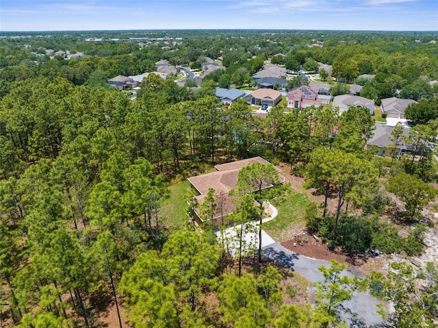 aerial view of property's location with a heavily wooded area and nearby suburban area