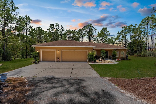 ranch-style house with an attached garage, driveway, a lawn, and stucco siding