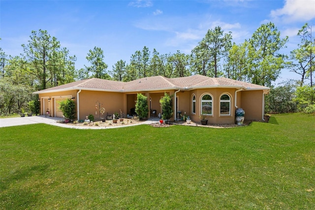 view of front of home with stucco siding, a garage, a front lawn, and driveway