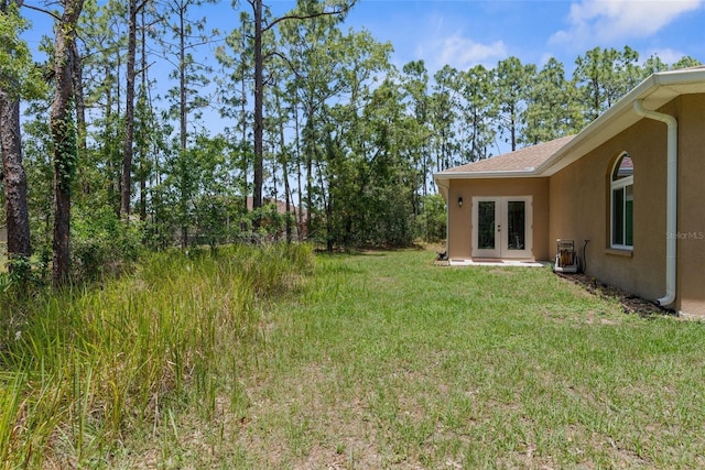 view of grassy yard featuring french doors