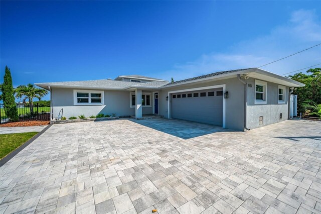 1620 Sea Breeze Dr, Tarpon Springs, FL 34689 - ranch-style house featuring stucco siding, a garage, and decorative driveway