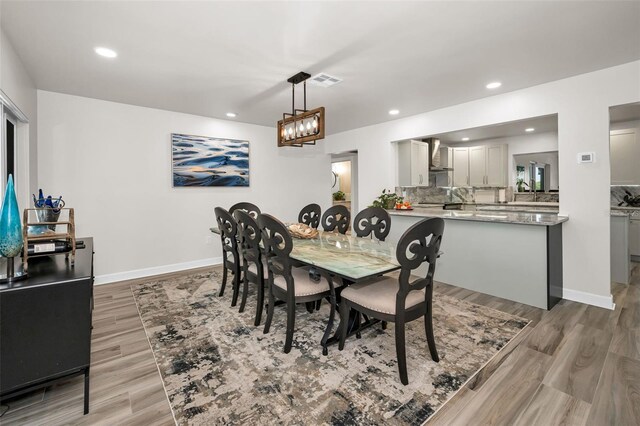 1620 Sea Breeze Dr, Tarpon Springs, FL 34689 - dining area featuring light wood finished floors, recessed lighting, baseboards, and a chandelier