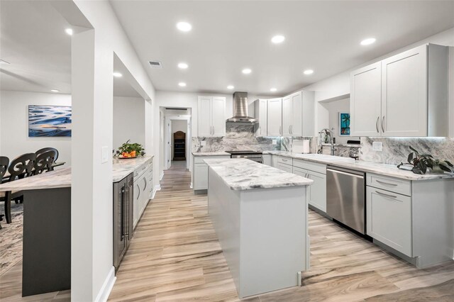 1620 Sea Breeze Dr, Tarpon Springs, FL 34689 - kitchen with appliances with stainless steel finishes, wall chimney exhaust hood, a kitchen island, a sink, and backsplash