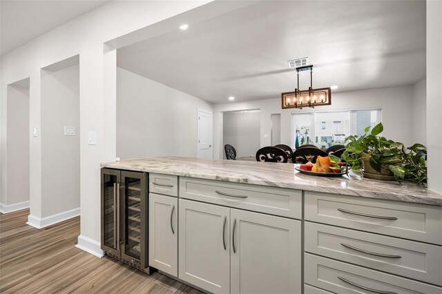 1620 Sea Breeze Dr, Tarpon Springs, FL 34689 - kitchen with wine cooler, light wood-type flooring, light stone counters, baseboards, and recessed lighting