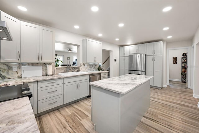 1620 Sea Breeze Dr, Tarpon Springs, FL 34689 - kitchen featuring appliances with stainless steel finishes, a center island, tasteful backsplash, light wood-style floors, and recessed lighting