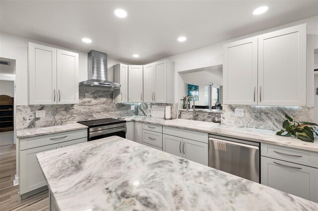 1620 Sea Breeze Dr, Tarpon Springs, FL 34689 - kitchen featuring wall chimney range hood, appliances with stainless steel finishes, a sink, tasteful backsplash, and recessed lighting
