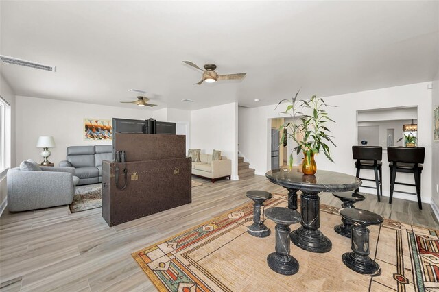 1620 Sea Breeze Dr, Tarpon Springs, FL 34689 - living room with light wood-style flooring, a ceiling fan, and stairs