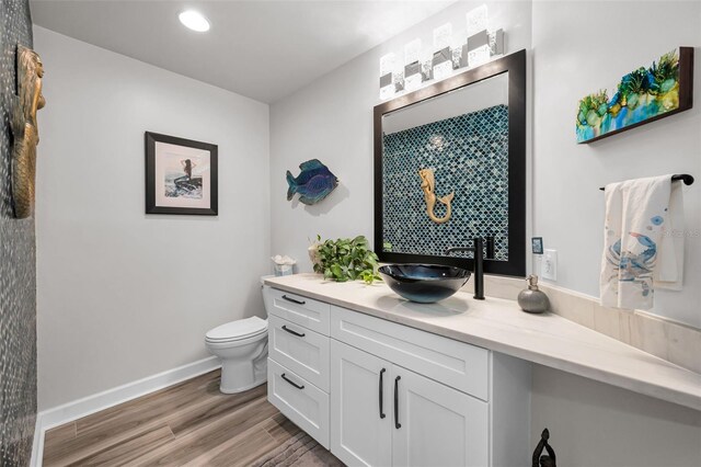 1620 Sea Breeze Dr, Tarpon Springs, FL 34689 - bathroom with vanity, toilet, wood finished floors, recessed lighting, and baseboards