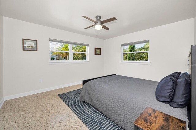 1620 Sea Breeze Dr, Tarpon Springs, FL 34689 - bedroom featuring multiple windows, speckled floor, baseboards, and a ceiling fan