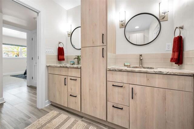 1620 Sea Breeze Dr, Tarpon Springs, FL 34689 - bathroom with two vanities, wood finished floors, and baseboards