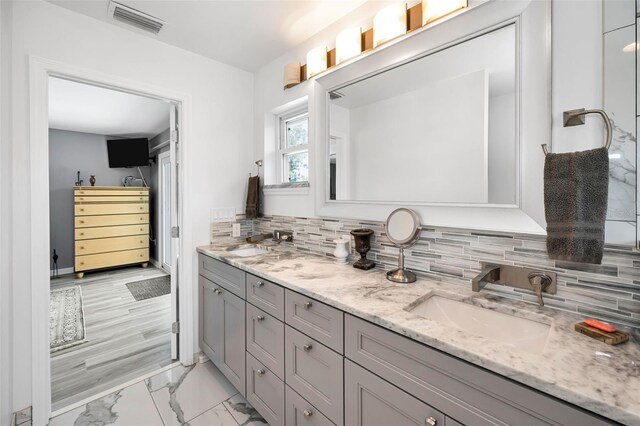 1620 Sea Breeze Dr, Tarpon Springs, FL 34689 - bathroom with double vanity, marble finish flooring, and decorative backsplash