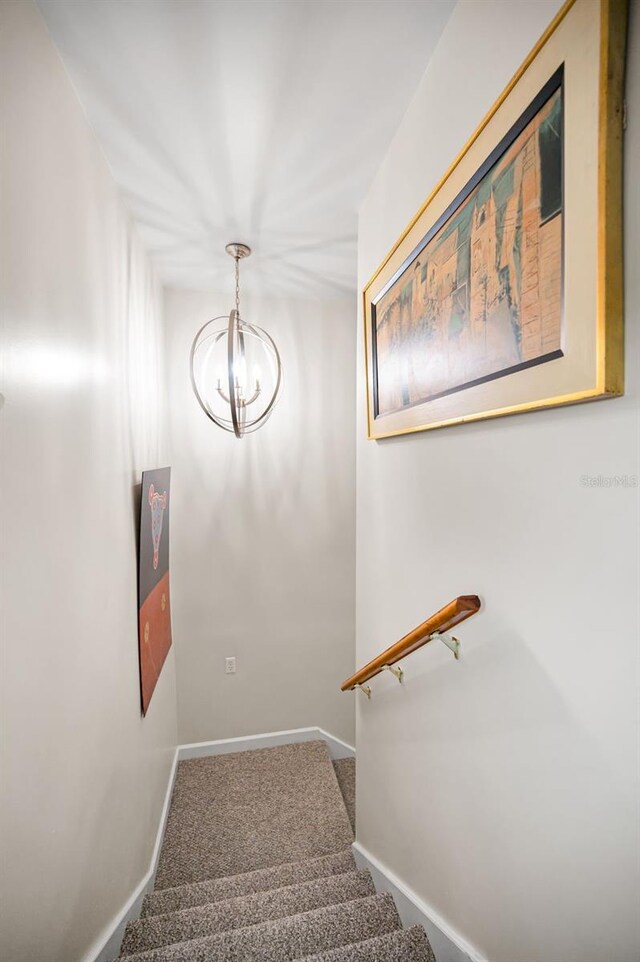 1620 Sea Breeze Dr, Tarpon Springs, FL 34689 - stairs featuring a chandelier, carpet, and baseboards