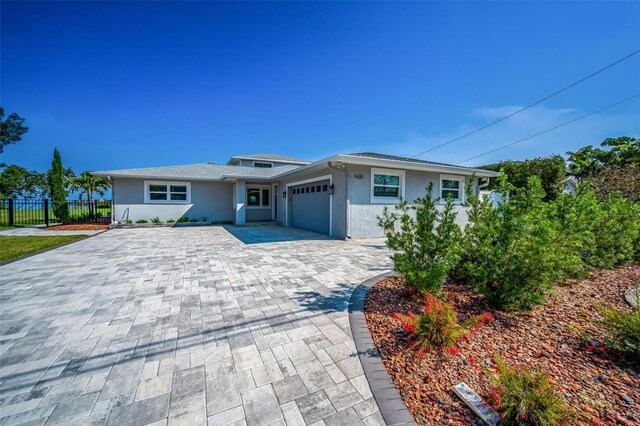 1620 Sea Breeze Dr, Tarpon Springs, FL 34689 - view of front facade with an attached garage, decorative driveway, and stucco siding