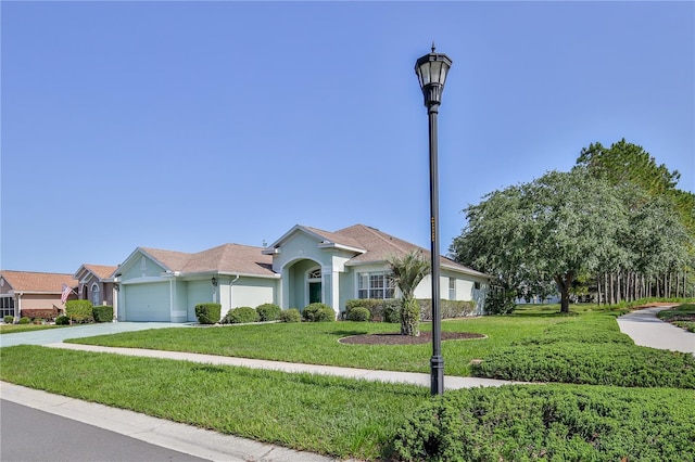 ranch-style home featuring an attached garage, a front yard, driveway, and stucco siding