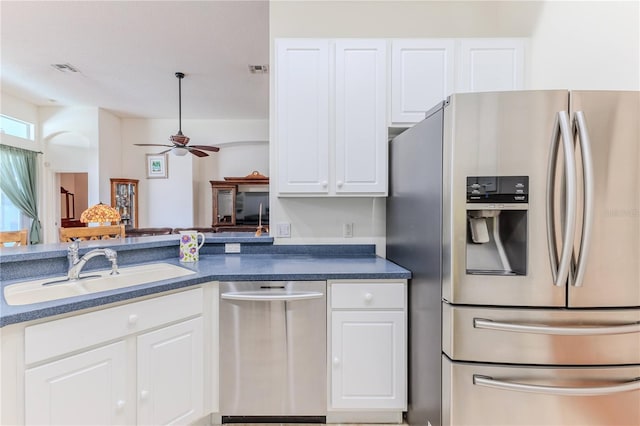 kitchen featuring stainless steel appliances, a sink, white cabinetry, and a ceiling fan