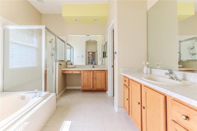 bathroom with a shower stall, tile patterned flooring, two vanities, and a bath