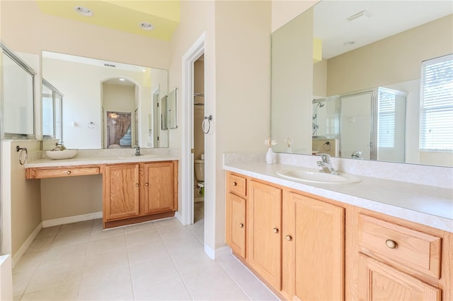 bathroom with a stall shower, toilet, tile patterned floors, two vanities, and baseboards