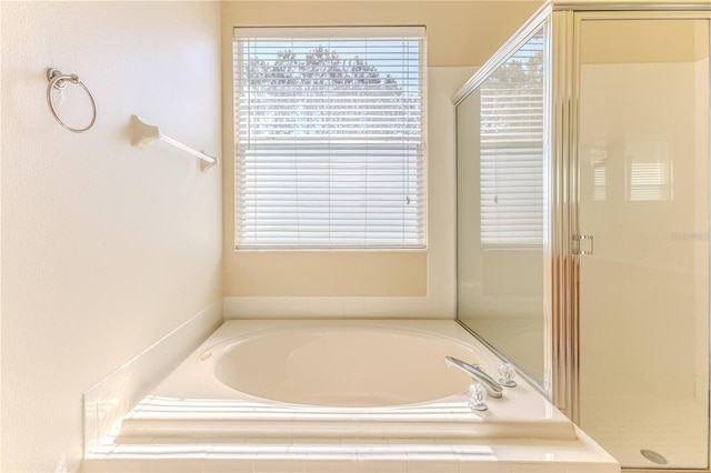 bathroom with a garden tub, plenty of natural light, and a shower stall