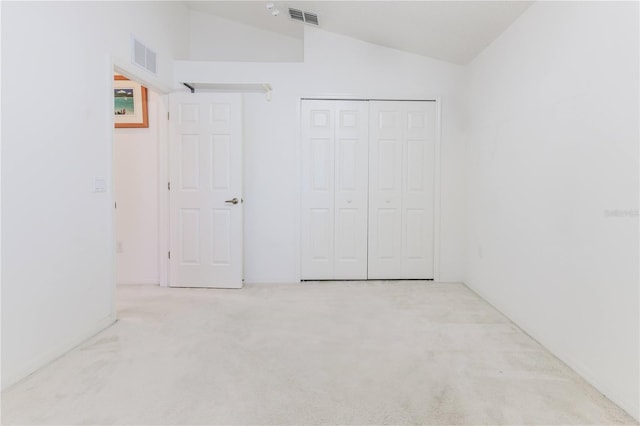 unfurnished bedroom with vaulted ceiling, carpet, and a closet