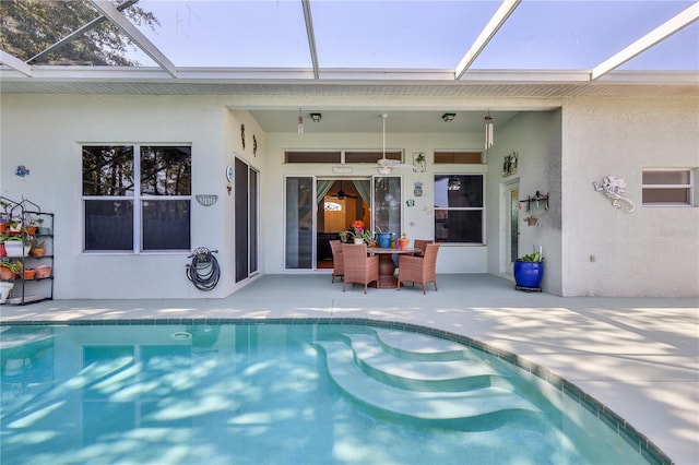 outdoor pool with a patio area and glass enclosure