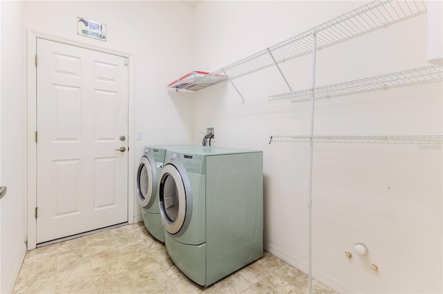 laundry room with washer and clothes dryer and baseboards