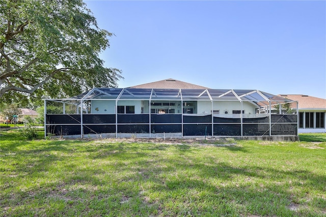 back of property featuring a lawn, glass enclosure, and stucco siding