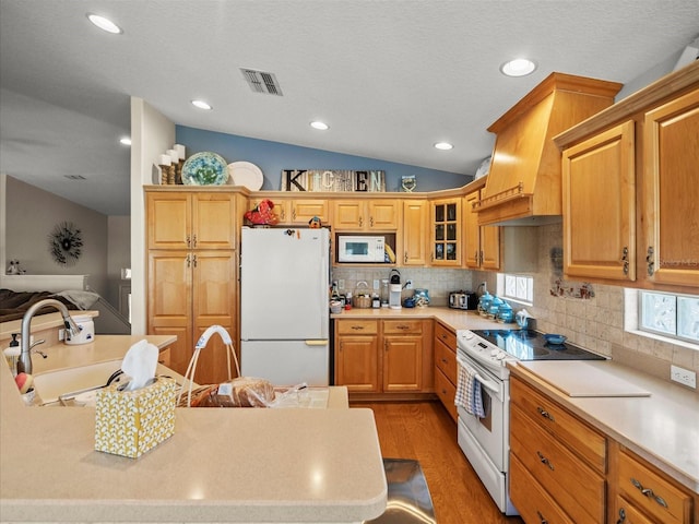 4292 Tahiti Dr, Hernando Beach, FL 34607 - kitchen with white appliances, vaulted ceiling, a sink, light wood-type flooring, and premium range hood