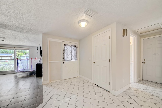 6231 Westport Dr, Port Richey, FL 34668 - entryway with light tile patterned flooring, baseboards, and a textured ceiling