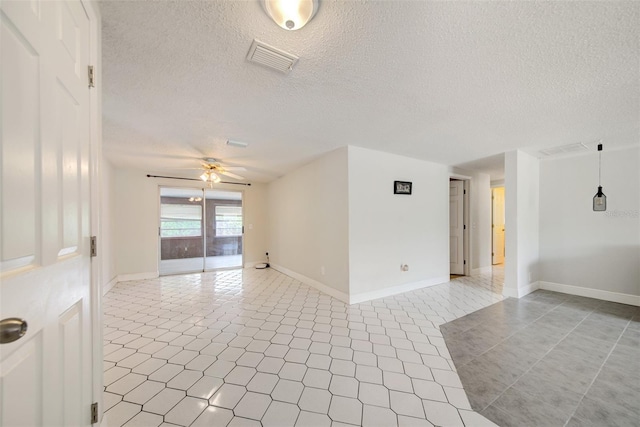 6231 Westport Dr, Port Richey, FL 34668 - spare room featuring a ceiling fan, light tile patterned floors, a textured ceiling, and baseboards