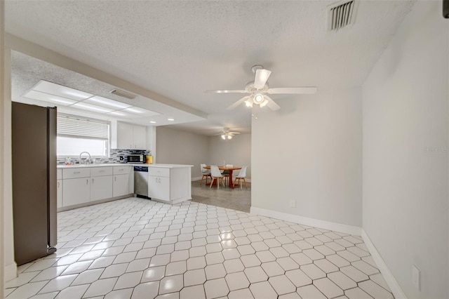 6231 Westport Dr, Port Richey, FL 34668 - kitchen with stainless steel appliances, a ceiling fan, light countertops, baseboards, and a textured ceiling
