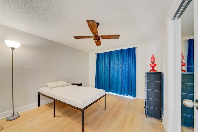 6231 Westport Dr, Port Richey, FL 34668 - bedroom featuring light wood-style floors, baseboards, a textured ceiling, and a ceiling fan