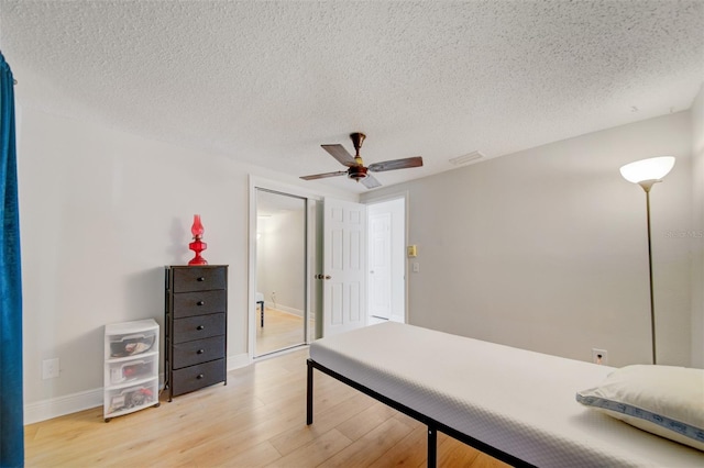 6231 Westport Dr, Port Richey, FL 34668 - bedroom featuring light wood finished floors, a textured ceiling, baseboards, and a ceiling fan