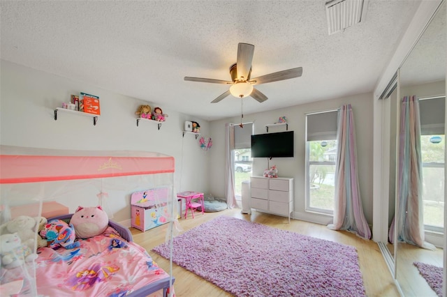 6231 Westport Dr, Port Richey, FL 34668 - bedroom with a textured ceiling, light wood-style flooring, and ceiling fan