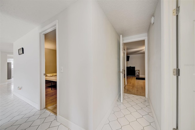 6231 Westport Dr, Port Richey, FL 34668 - hallway featuring light tile patterned floors, a textured ceiling, and baseboards