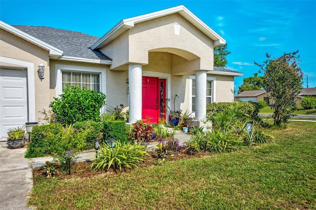 view of front of house with a front lawn, stucco siding, and roof with shingles