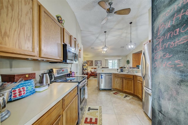 kitchen with stainless steel appliances, a ceiling fan, open floor plan, light countertops, and a textured ceiling