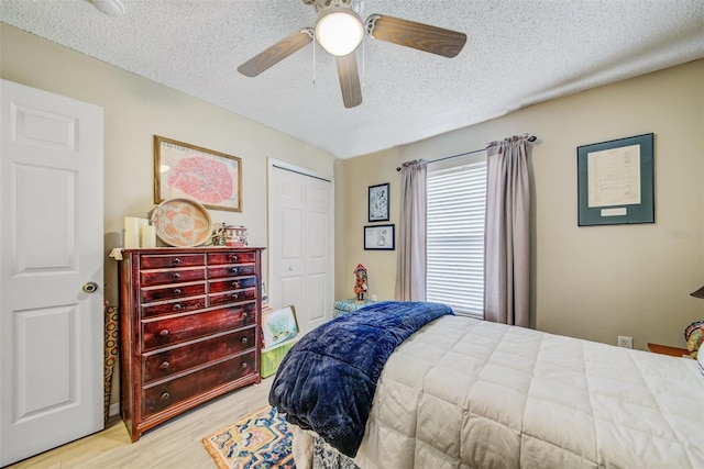 bedroom featuring wood finished floors, a textured ceiling, a closet, and ceiling fan