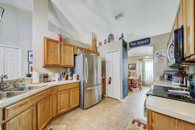 kitchen featuring stainless steel appliances, high vaulted ceiling, light tile patterned floors, a sink, and a textured ceiling