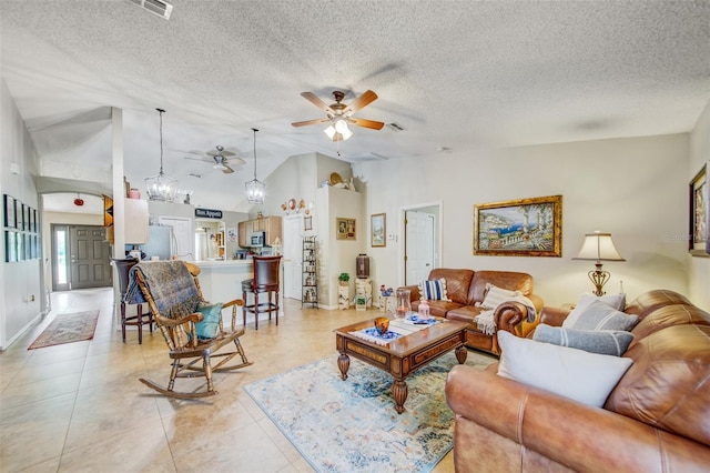 living area featuring ceiling fan, lofted ceiling, a textured ceiling, light tile patterned floors, and a chandelier