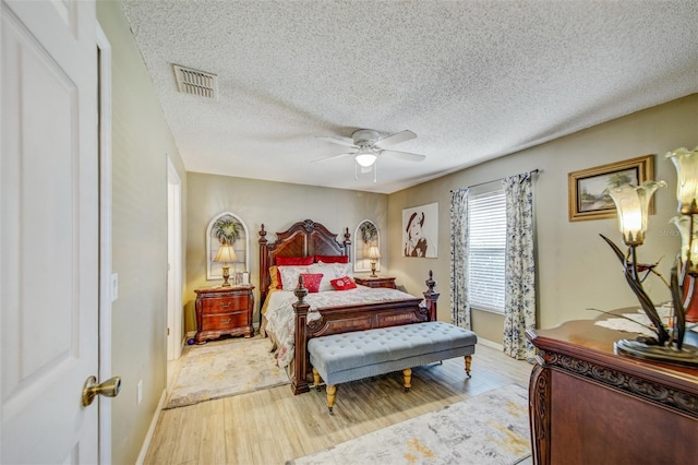 bedroom featuring wood finished floors, baseboards, ceiling fan, and a textured ceiling