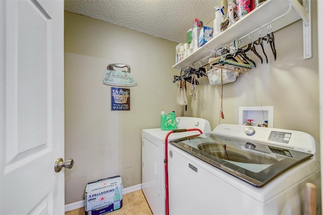 laundry area featuring separate washer and dryer, baseboards, a textured ceiling, and light tile patterned floors