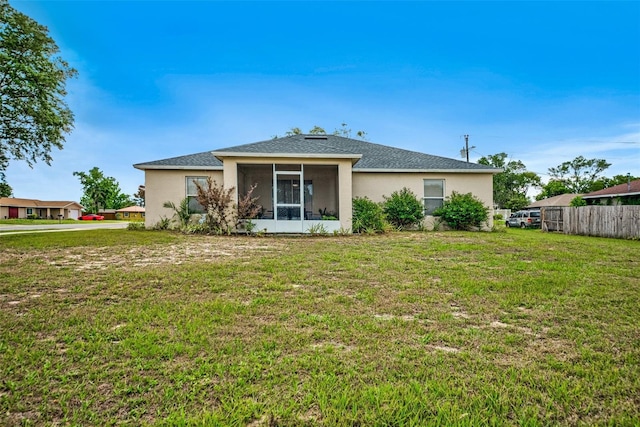 back of property featuring a sunroom and stucco siding