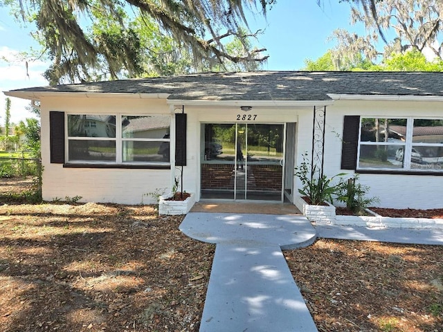 2827 SE 2nd St, Ocala, FL 34471 - view of exterior entry featuring roof with shingles