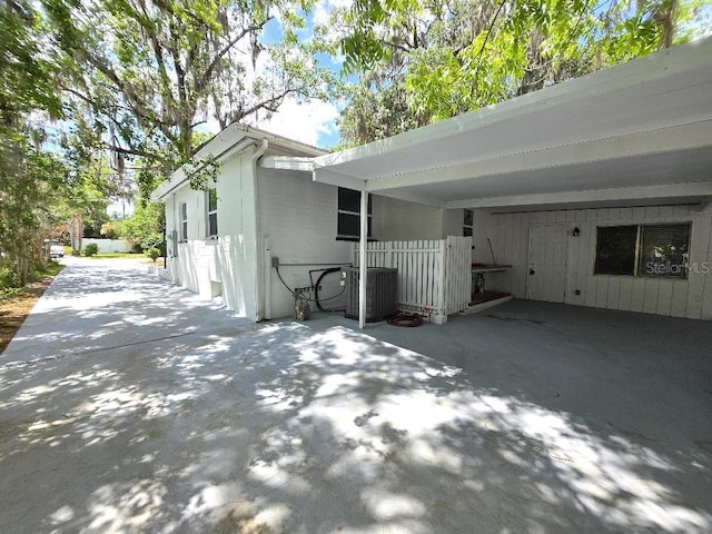 2827 SE 2nd St, Ocala, FL 34471 - view of side of home with central AC unit, fence, and a carport