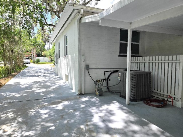 2827 SE 2nd St, Ocala, FL 34471 - view of home's exterior with concrete block siding, central air condition unit, a patio, and fence