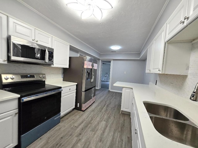 2827 SE 2nd St, Ocala, FL 34471 - kitchen featuring stainless steel appliances, a sink, white cabinets, light wood-style flooring, and a textured ceiling