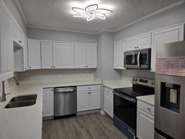 2827 SE 2nd St, Ocala, FL 34471 - kitchen featuring stainless steel appliances, a sink, a textured ceiling, dark wood-type flooring, and light countertops