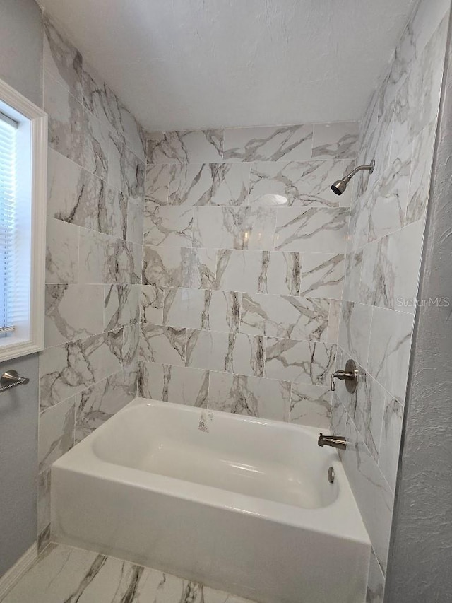 2827 SE 2nd St, Ocala, FL 34471 - full bathroom featuring shower / bathtub combination, marble look tile flooring, and baseboards