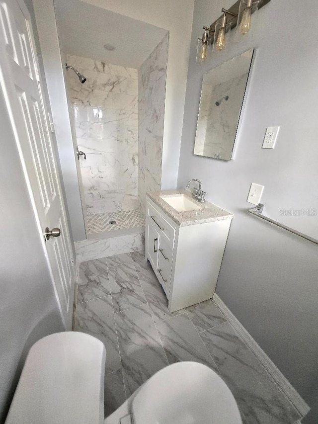 2827 SE 2nd St, Ocala, FL 34471 - bathroom featuring marble finish floors, tiled shower, vanity, and baseboards